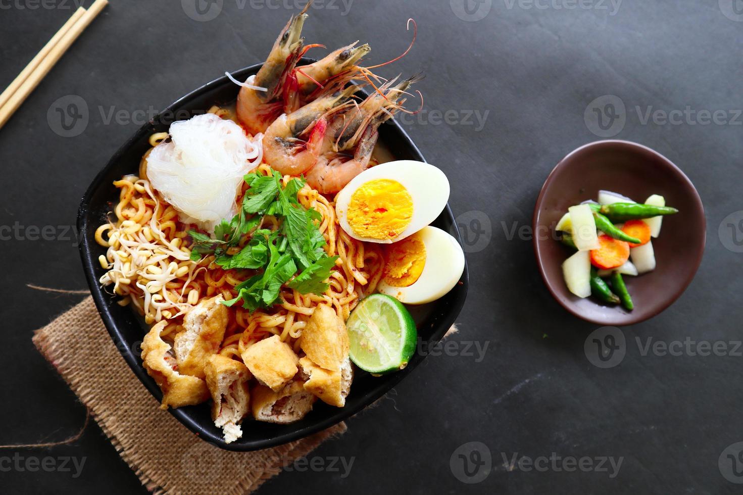 laksa, laksa curry made from vermicelli, noodles, bean sprouts, egg, tofu lime, and shrimp with a spicy soup sauce that is rich in spices. laksa served on bowl, isolated on white background. photo