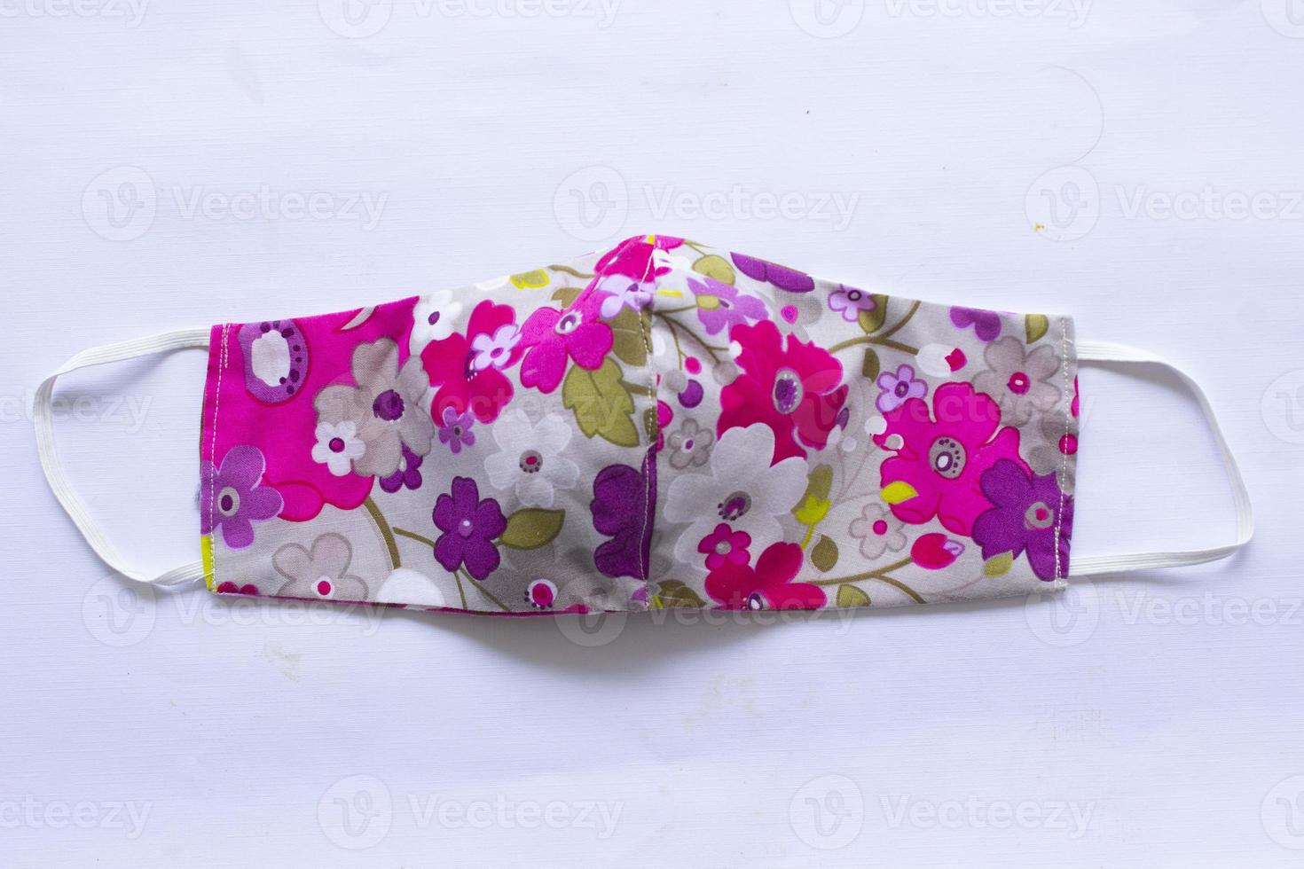 cloth mask or fabric face mask with cotton fabric flower pattern handmade crafts isolated on white background. This hygienic mask for cover mouth and protection with beautiful sewing fashion. photo