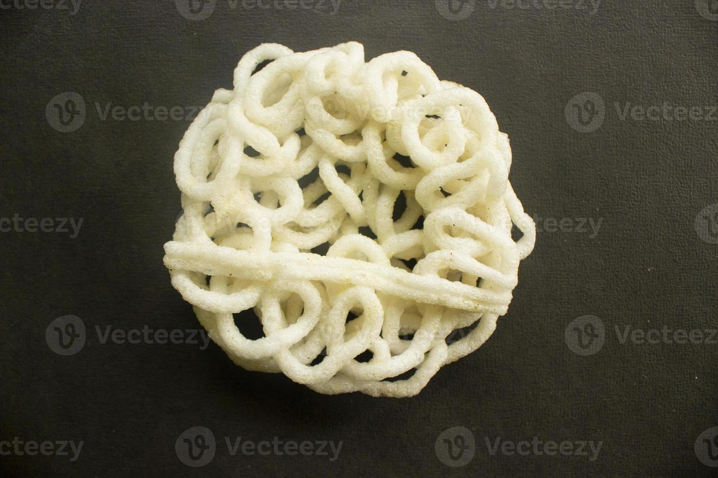 kerupuk or krupuk or crackers isolated on black background. kerupuk is snacks made from tapioca flour dough mixed with flavorings such as shrimp or fish. traditional snack from indonesia photo