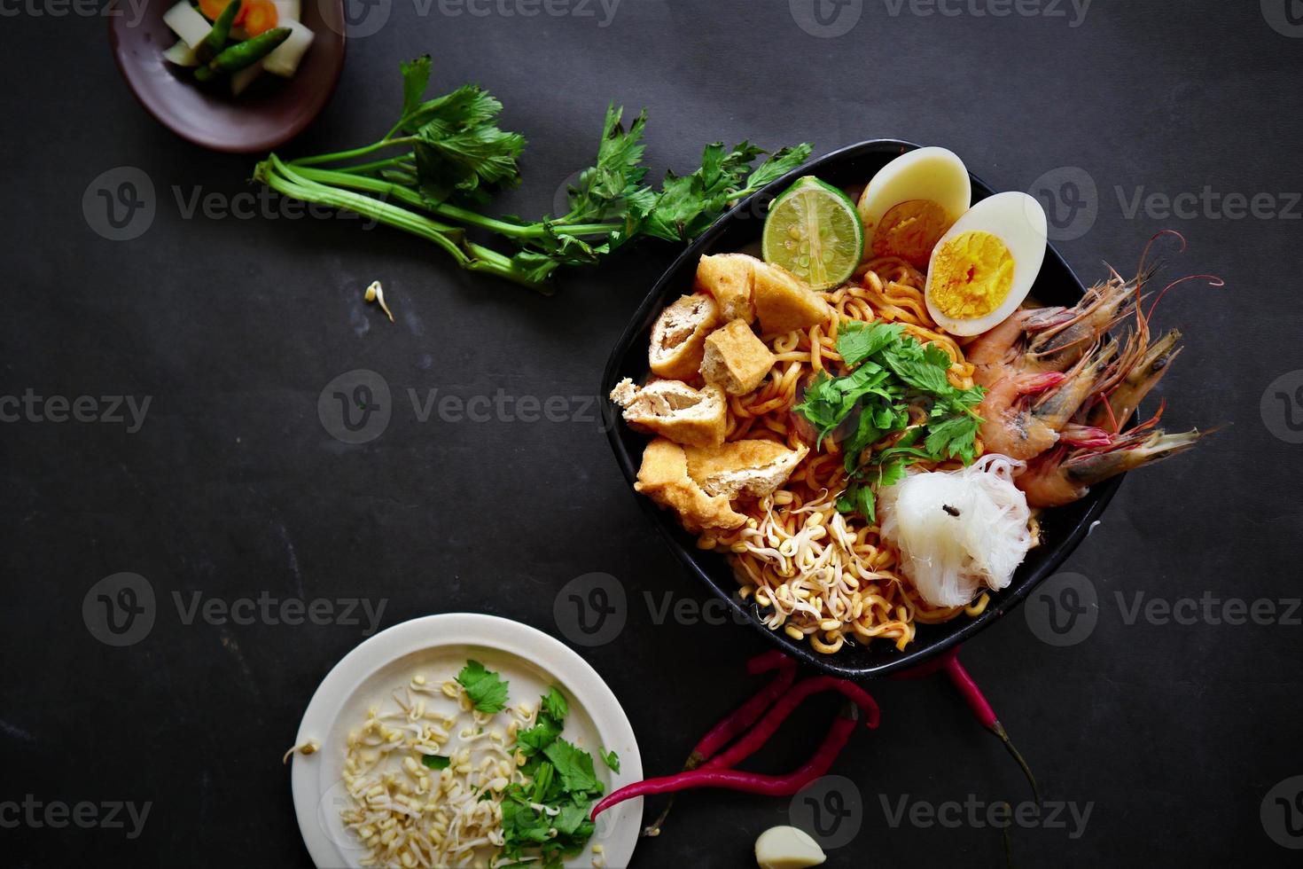 laksa, laksa curry made from vermicelli, noodles, bean sprouts, egg, tofu lime, and shrimp with a spicy soup sauce that is rich in spices. laksa served on bowl, isolated on white background. photo