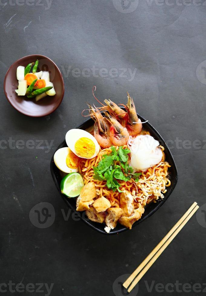 laksa, laksa curry made from vermicelli, noodles, bean sprouts, egg, tofu lime, and shrimp with a spicy soup sauce that is rich in spices. laksa served on bowl, isolated on white background. photo