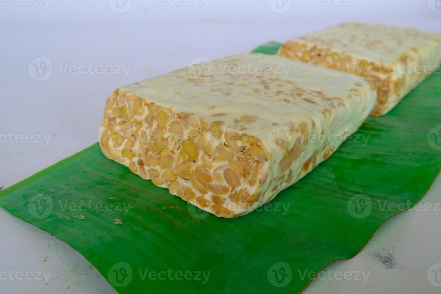 Raw tempeh or tempe. tempeh slices in white background. raw soybean seeds. Tempe is a traditional Indonesian food made from fermented soybeans. photo