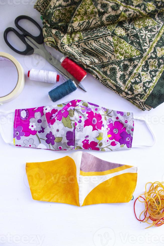 cloth mask or fabric face mask with cotton fabric flower pattern handmade crafts isolated on white background. This hygienic mask for cover mouth and protection with beautiful sewing fashion. photo