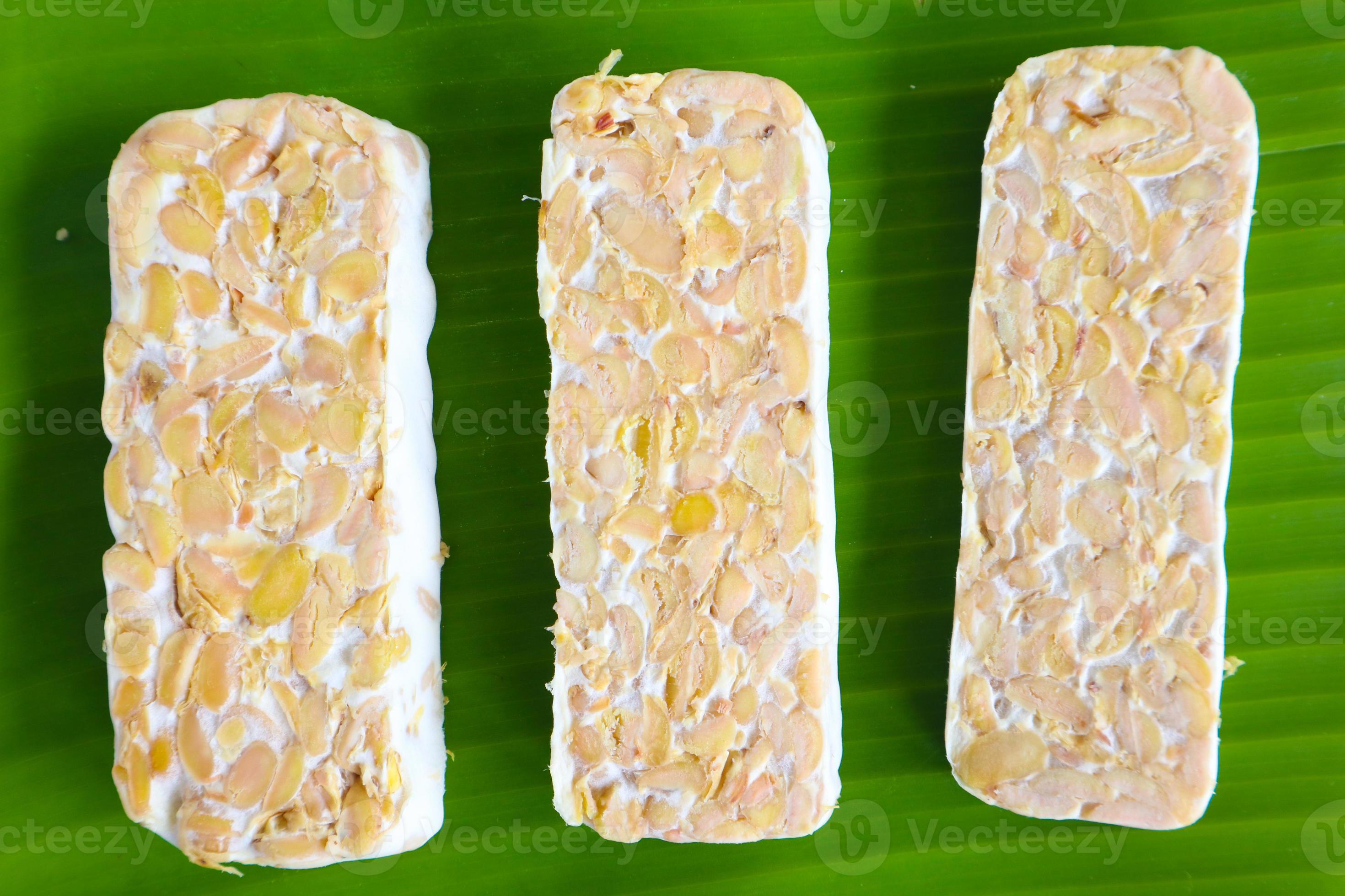  tempeh crudo o tempe. rebanadas de tempeh en fondo blanco. semillas de ...