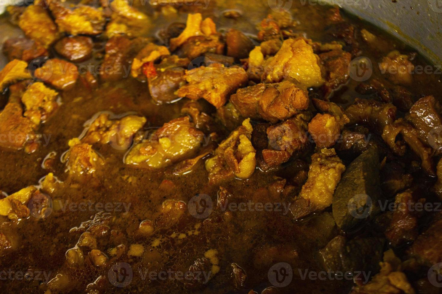 Traditional cooking raw meat with yellow curry or Tongseng in pan. Tongseng is traditional curry food from central java indonesia photo