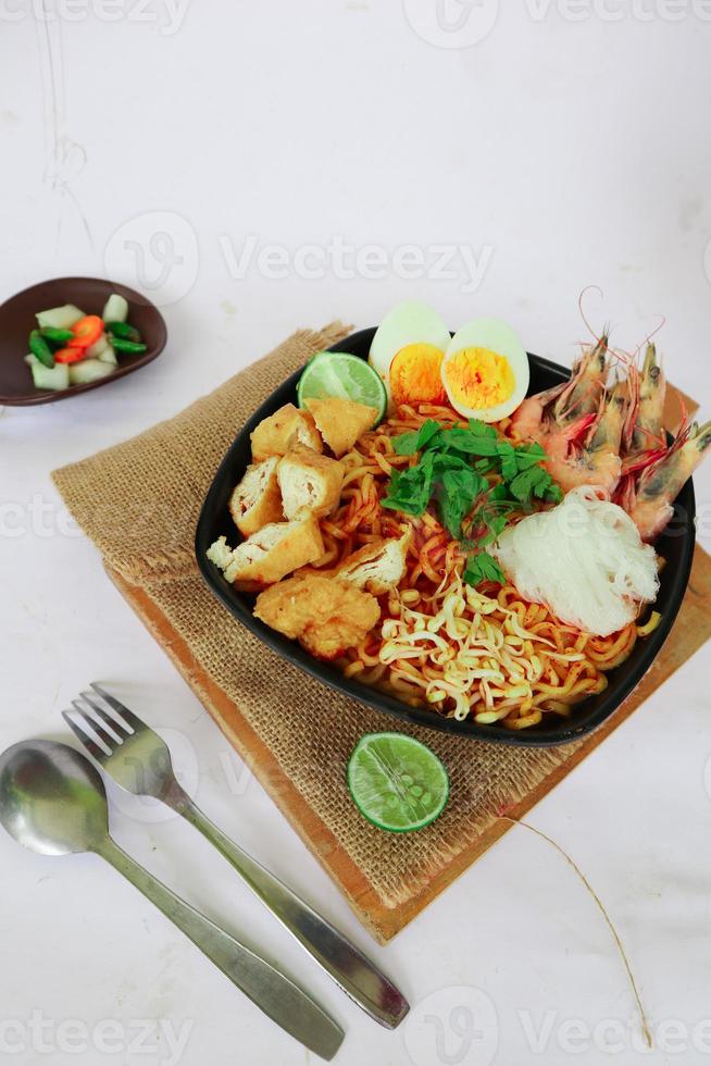 laksa, laksa curry made from vermicelli, noodles, bean sprouts, egg, tofu lime, and shrimp with a spicy soup sauce that is rich in spices. laksa served on bowl, isolated on white background. photo