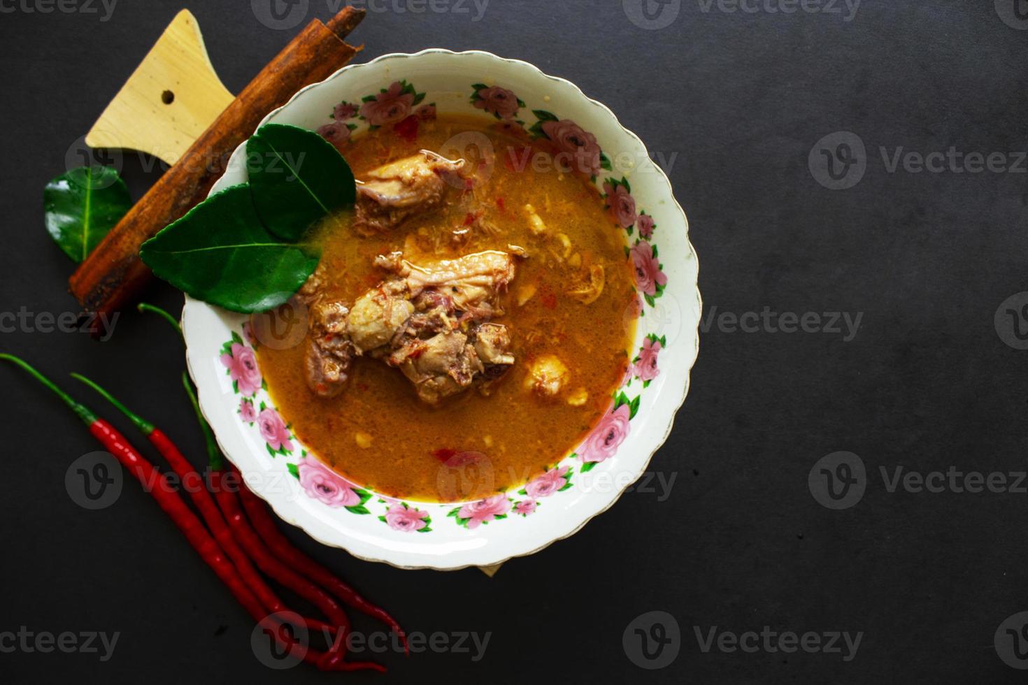 chicken curry or kari ayam served on bowl, isolated on white background photo