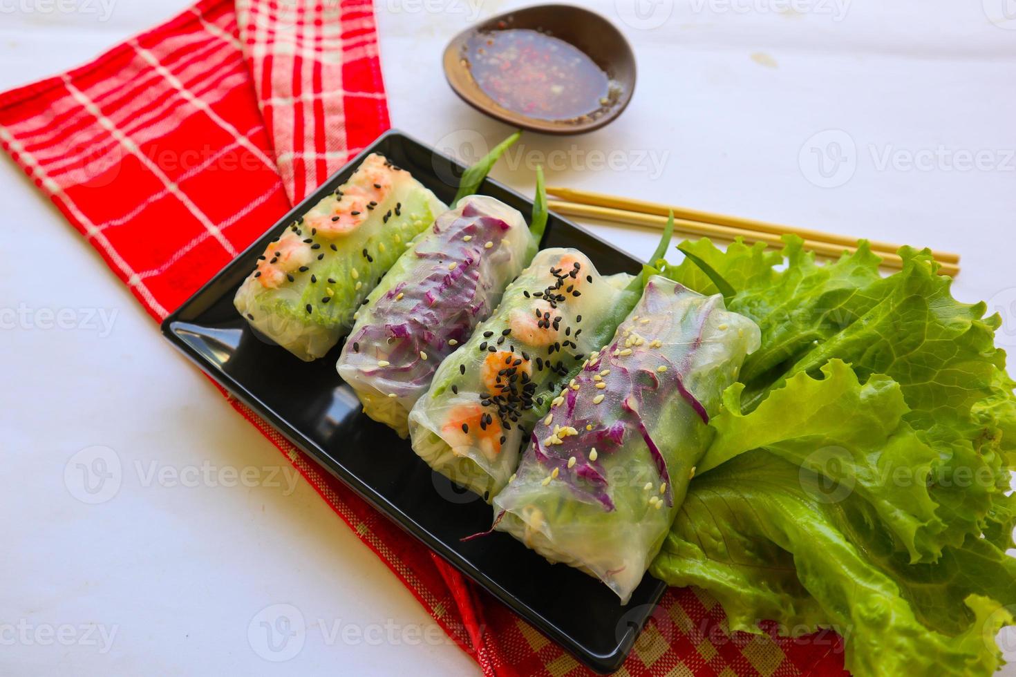 Goi cuon is a traditional spring roll from Vietnam , Vietnamese food, made from meat, shrimp, vegetables, vermicelli, wrapped in rice paper or banh trang. served with sauce photo