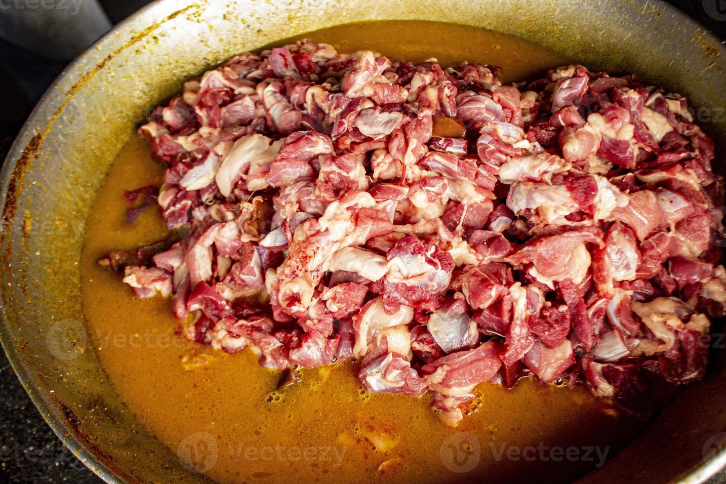 Traditional cooking raw meat with yellow curry or Tongseng in pan. Tongseng is traditional curry food from central java indonesia photo