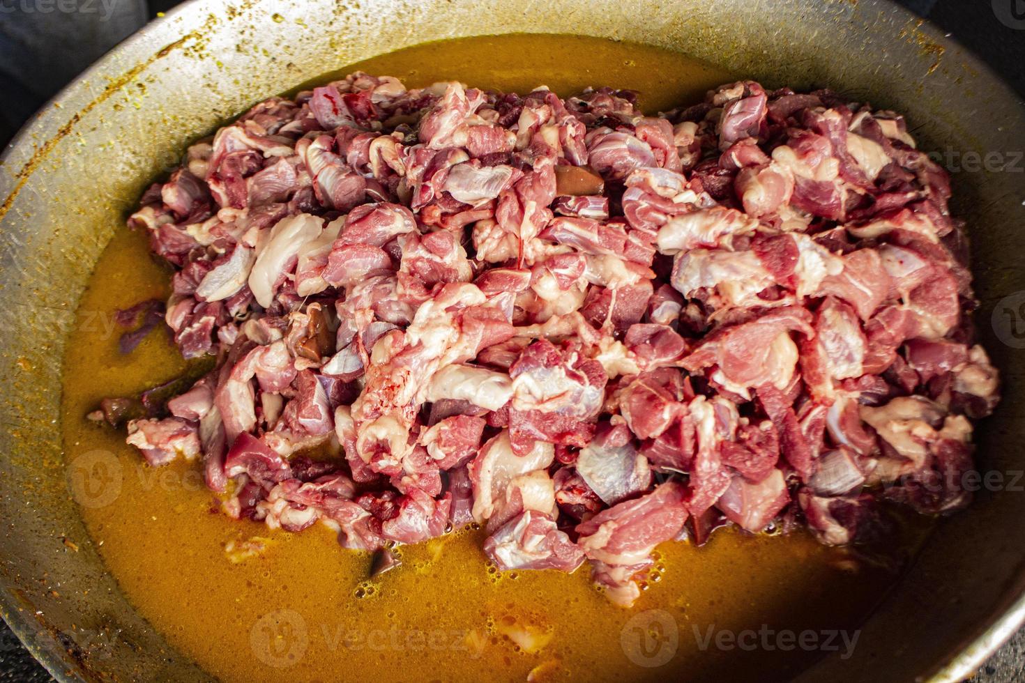 Traditional cooking raw meat with yellow curry or Tongseng in pan. Tongseng is traditional curry food from central java indonesia photo