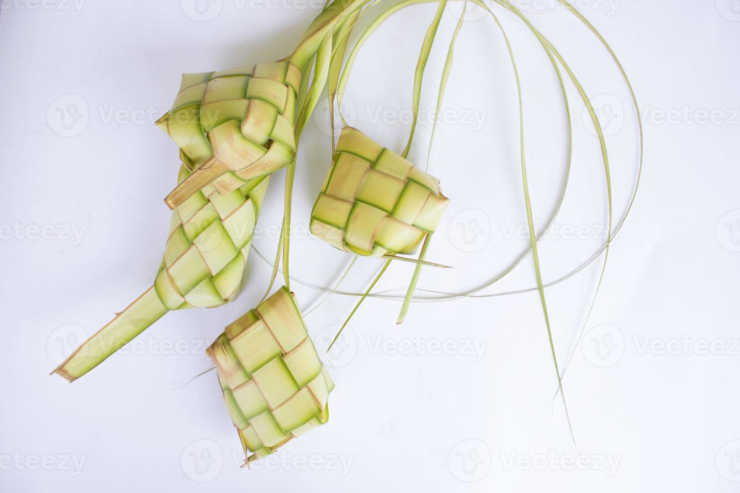 ketupat in earthenware plate isolated on white background. Ketupat ,Rice Dumpling is food served when idhul fitri eid mubarak in Indonesia, made from rice wrapped in young coconut leaves, janur photo