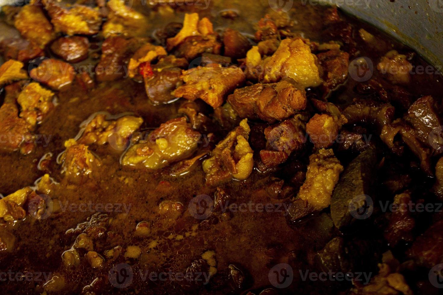 Traditional cooking raw meat with yellow curry or Tongseng in pan. Tongseng is traditional curry food from central java indonesia photo