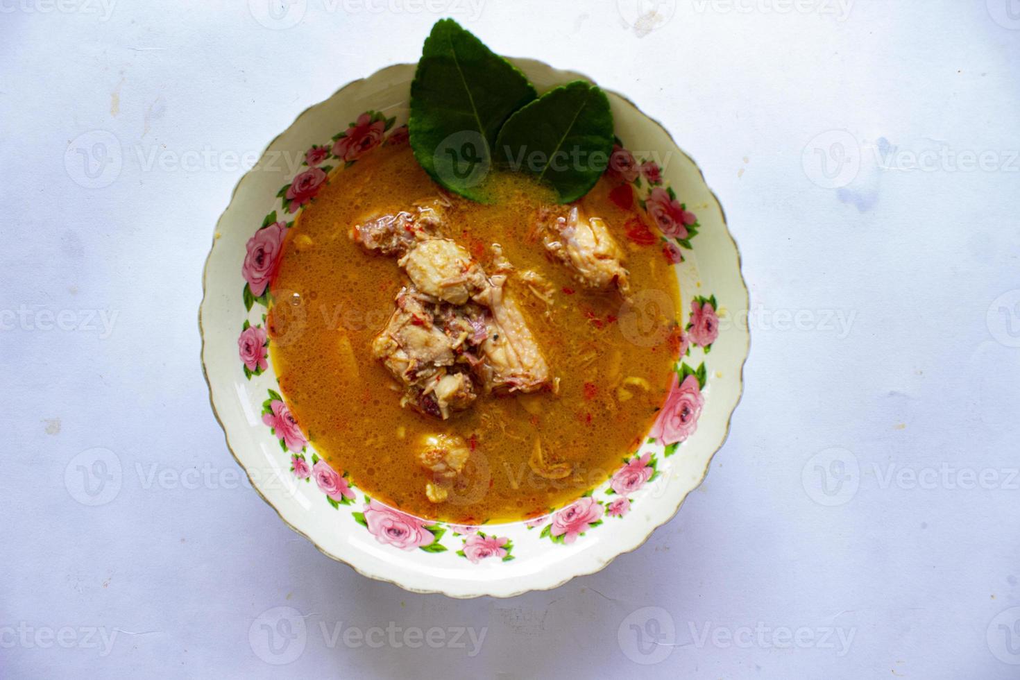 chicken curry or kari ayam served on bowl, isolated on white background photo