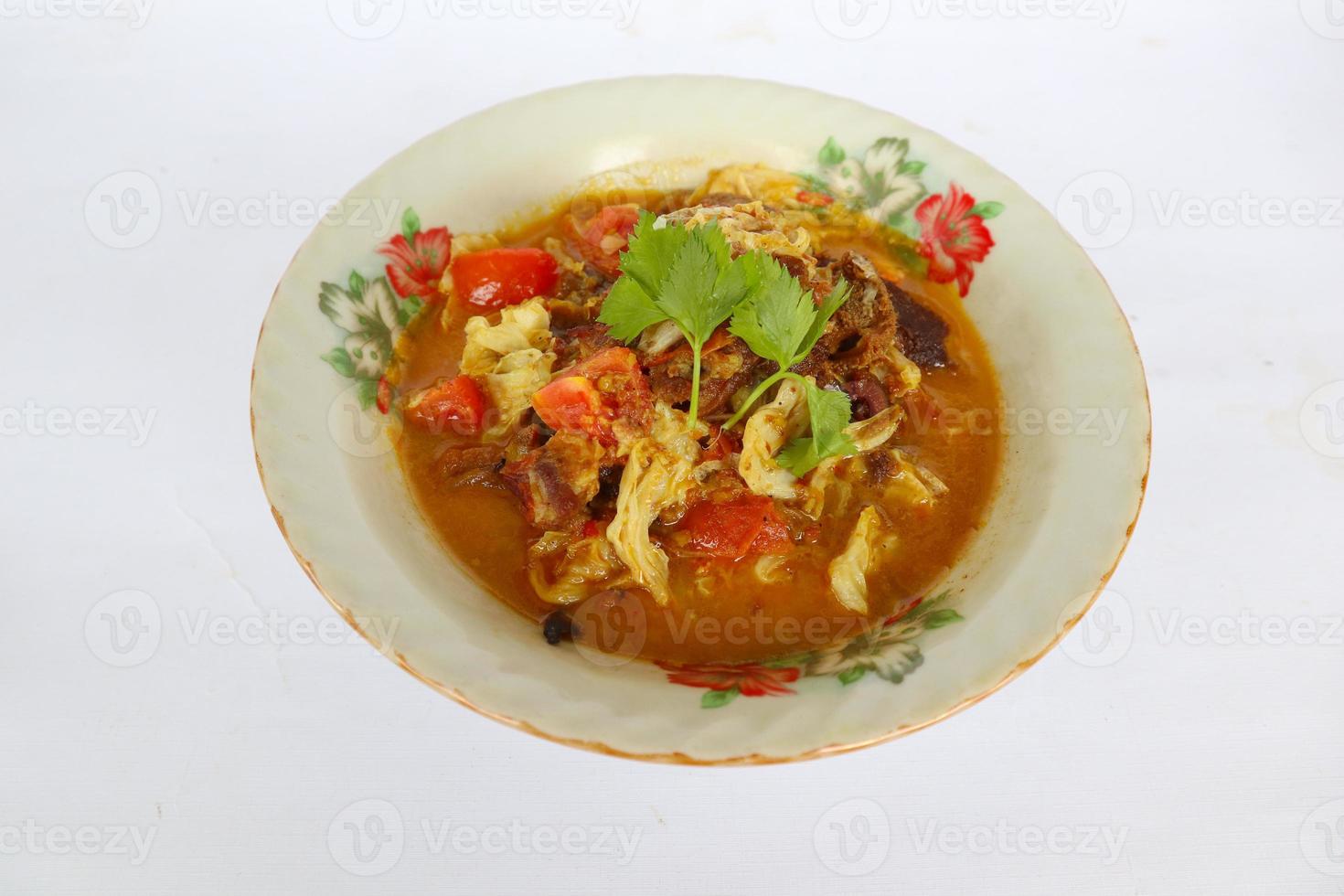 Goat Curry or gulai kambing, food from asia. Delicious goat meat curry served in a bowl.served with tomato, seasoning, celery and cabbage photo