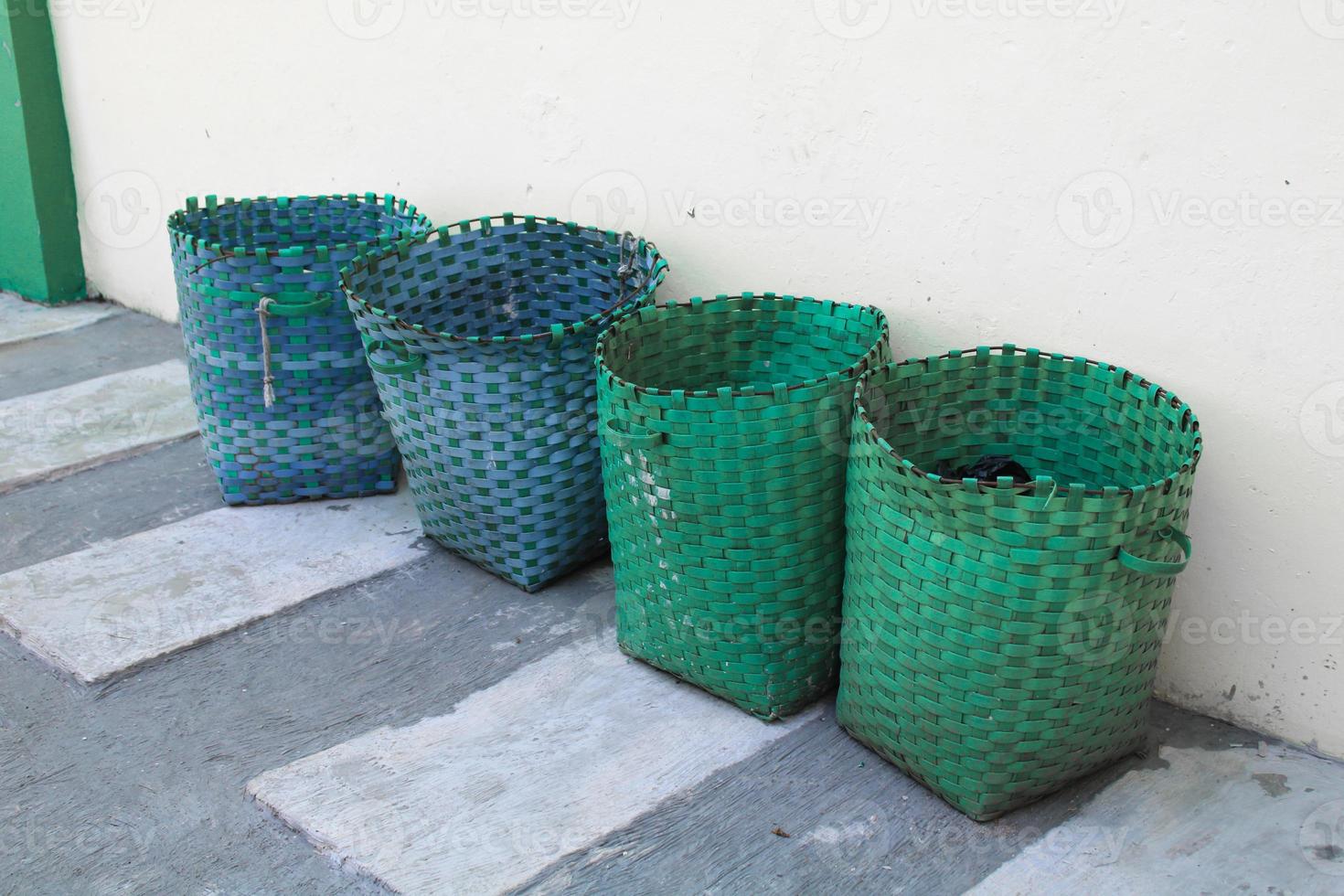 basket, plastic basket serves as a trash can.garbage trash can can outside against wall photo