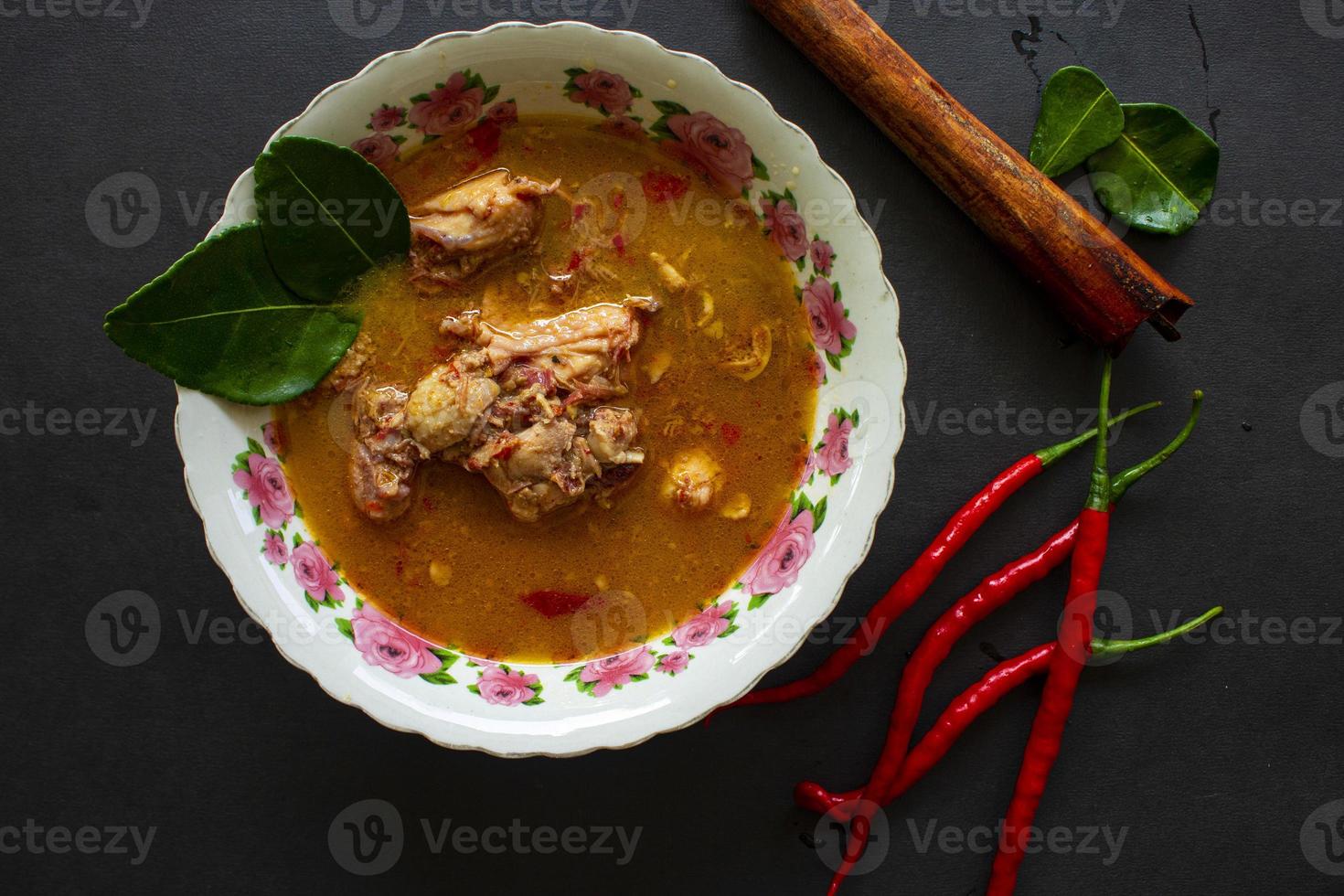 chicken curry or kari ayam served on bowl, isolated on white background photo