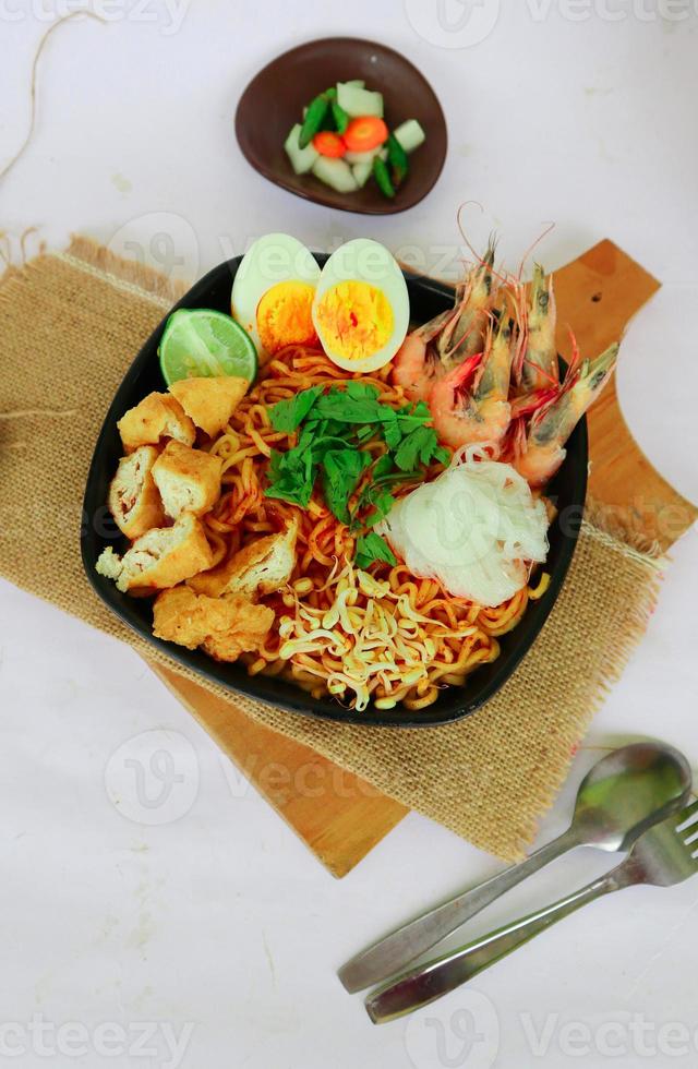 laksa, laksa curry made from vermicelli, noodles, bean sprouts, egg, tofu lime, and shrimp with a spicy soup sauce that is rich in spices. laksa served on bowl, isolated on white background. photo