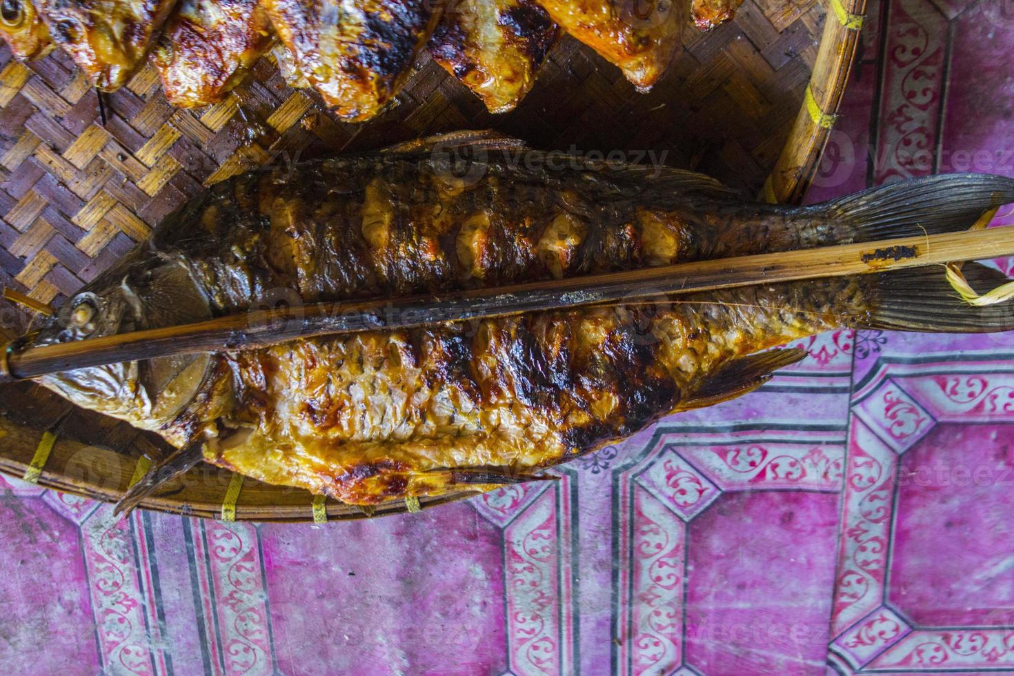 pescado a la parrilla, pescado a la parrilla tilapia del nilo a la parrilla sobre carbón caliente foto