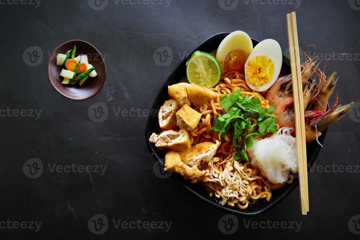 laksa, laksa curry made from vermicelli, noodles, bean sprouts, egg, tofu lime, and shrimp with a spicy soup sauce that is rich in spices. laksa served on bowl, isolated on white background. photo