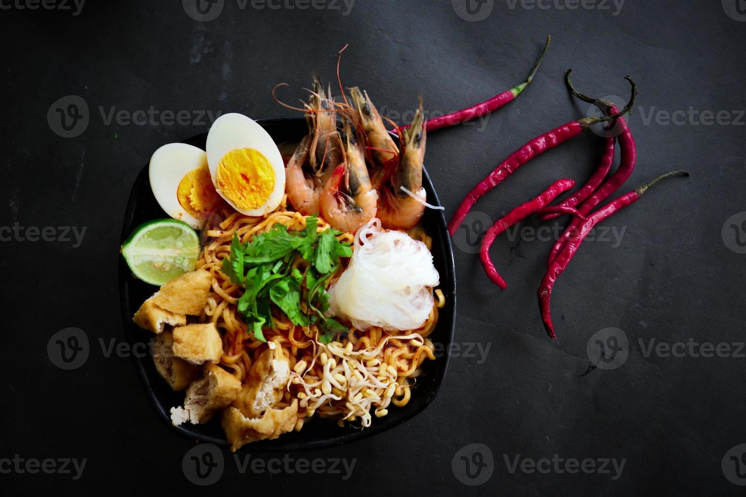 laksa, laksa curry made from vermicelli, noodles, bean sprouts, egg, tofu lime, and shrimp with a spicy soup sauce that is rich in spices. laksa served on bowl, isolated on white background. photo