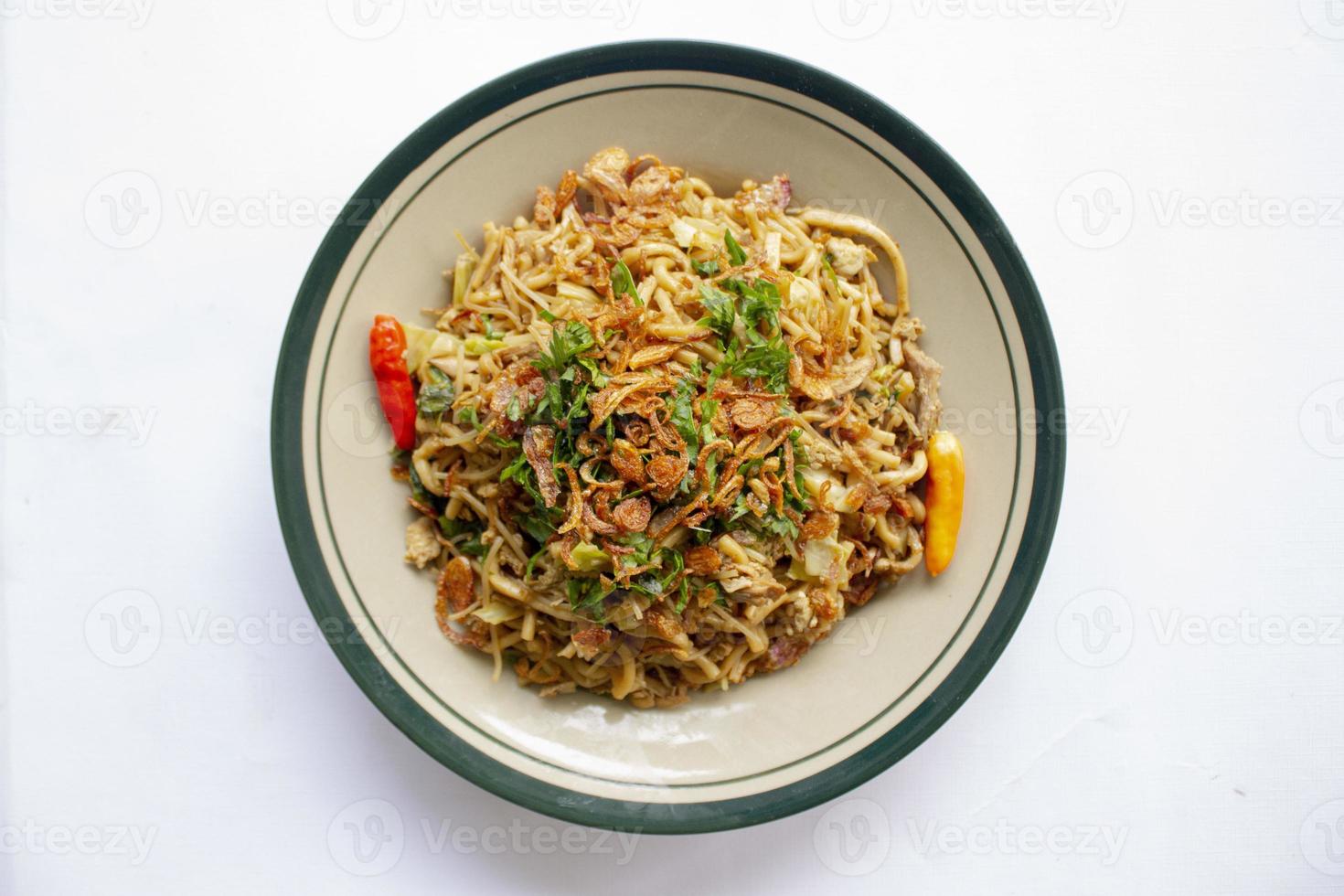 Mie Goreng Jawa or bakmi jawa or java noodle with spoon and fork. Indonesian traditional street food noodles from central java or Yogyakarta, indonesia on white background photo