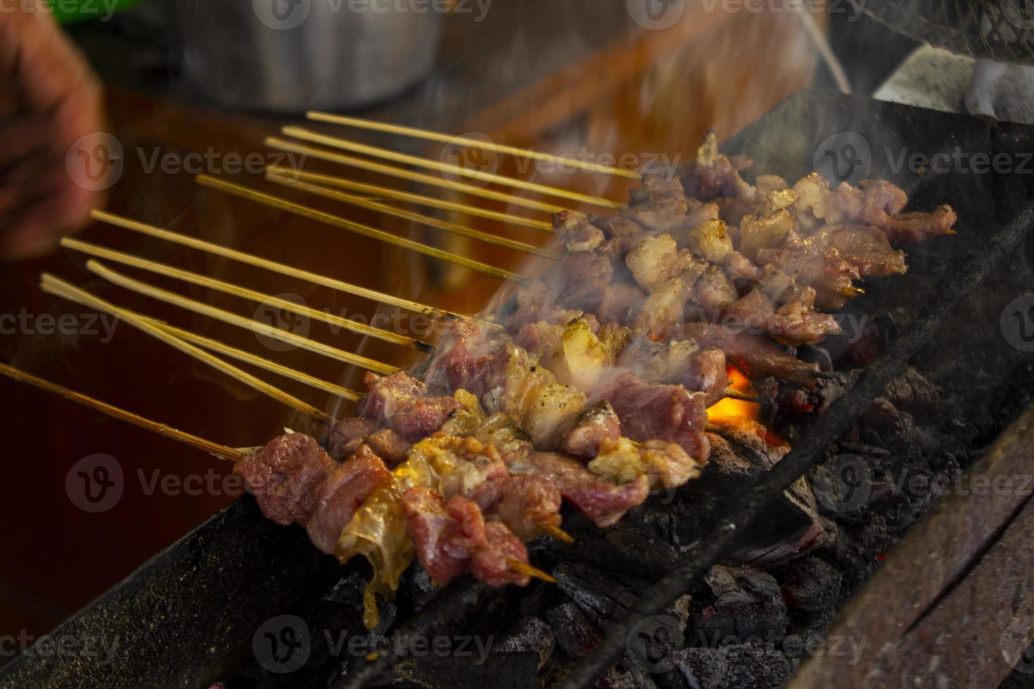 sate kambing o satay de cabra, cordero, cordero o carne de cabra satay con ingrediente de carbón en fuego rojo asado por personas. satay tradicional de yogyakarta, java, indonesia satay de cocina foto