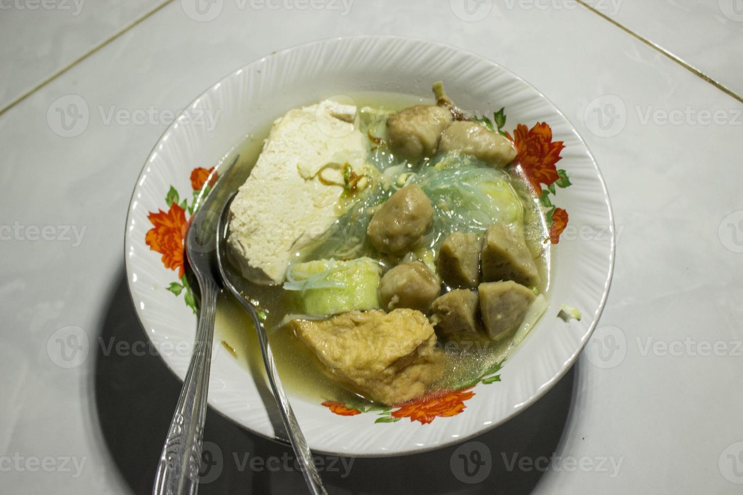 bakso urat o músculos de albóndigas es una comida tradicional popular hecha de carne y músculos de vaca servida con verduras, fideos y sopa de sabor servida en un tazón foto