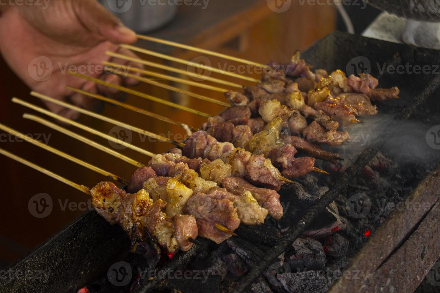 sate kambing o satay de cabra, cordero, cordero o carne de cabra satay con ingrediente de carbón en fuego rojo asado por personas. satay tradicional de yogyakarta, java, indonesia satay de cocina foto