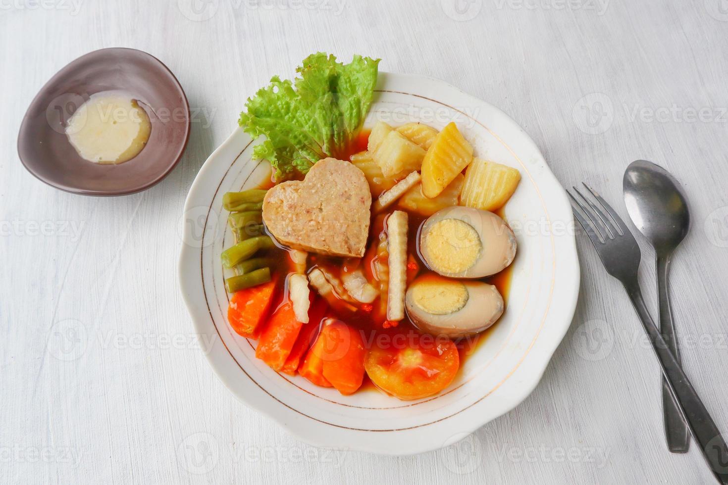 selat solo is traditional salad food from indonesia. made from hard-boiled eggs, boiled chickpeas, boiled carrots, hash browns and lettuce, steak or bistik. served on wood table photo