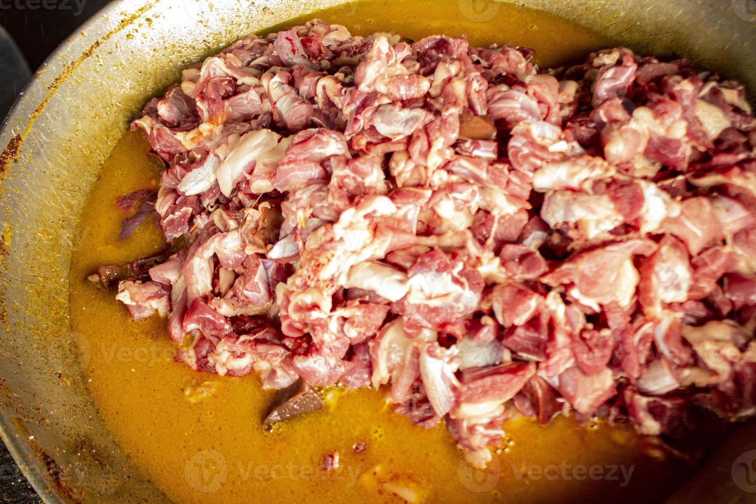 Traditional cooking raw meat with yellow curry or Tongseng in pan. Tongseng is traditional curry food from central java indonesia photo