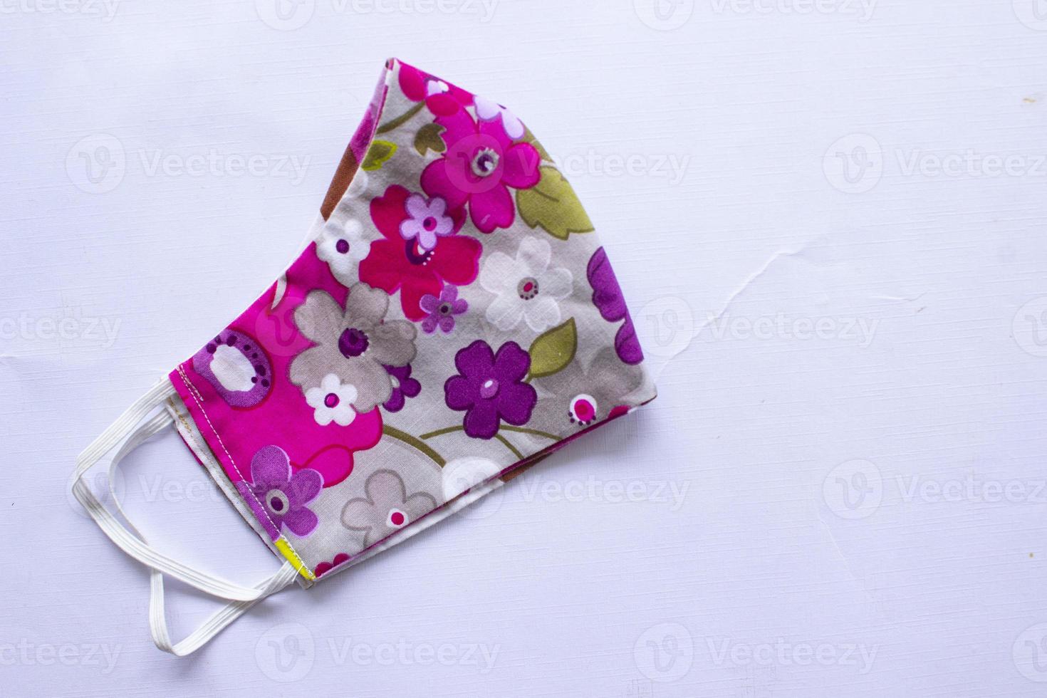 cloth mask or fabric face mask with cotton fabric flower pattern handmade crafts isolated on white background. This hygienic mask for cover mouth and protection with beautiful sewing fashion. photo