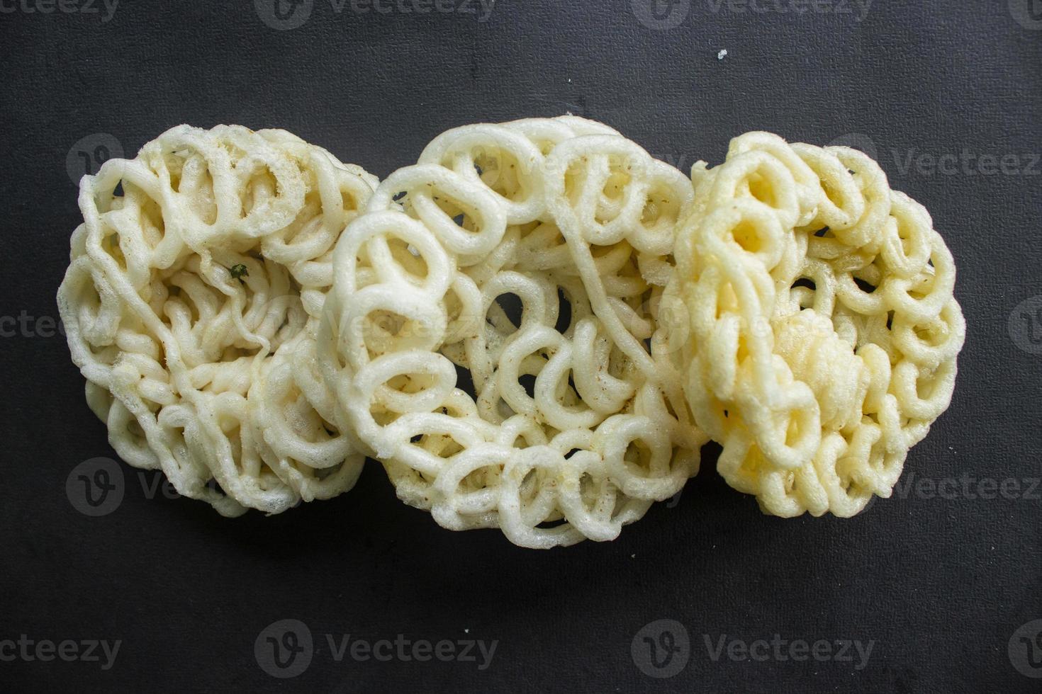 kerupuk or krupuk or crackers isolated on black background. kerupuk is snacks made from tapioca flour dough mixed with flavorings such as shrimp or fish. traditional snack from indonesia photo
