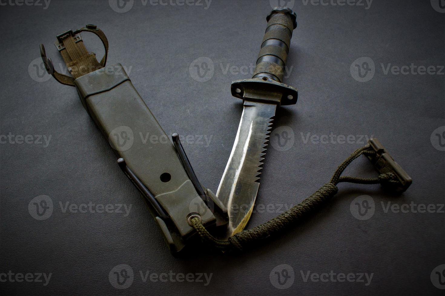 dark black military knife on black background photo