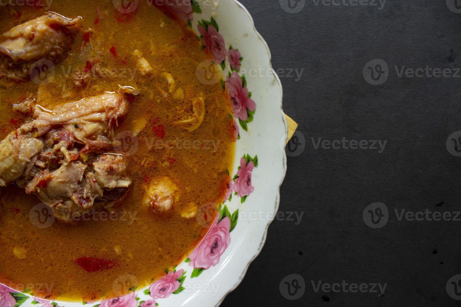 chicken curry or kari ayam served on bowl, isolated on white background photo