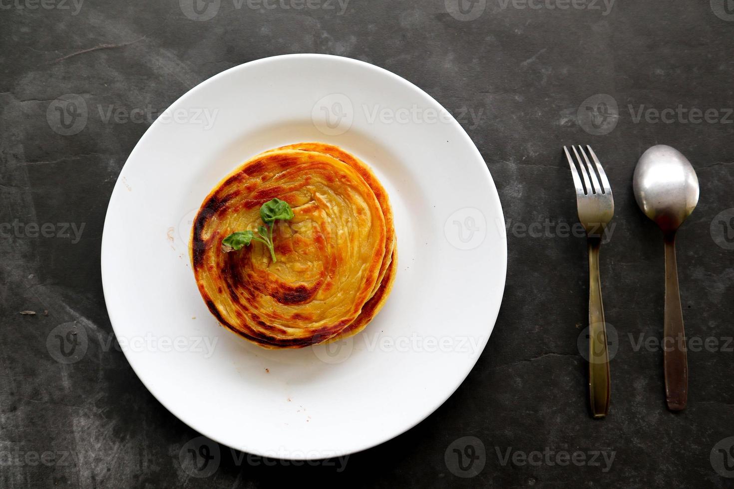 paratha bread or canai bread or roti maryam, favorite breakfast dish. served on plate photo