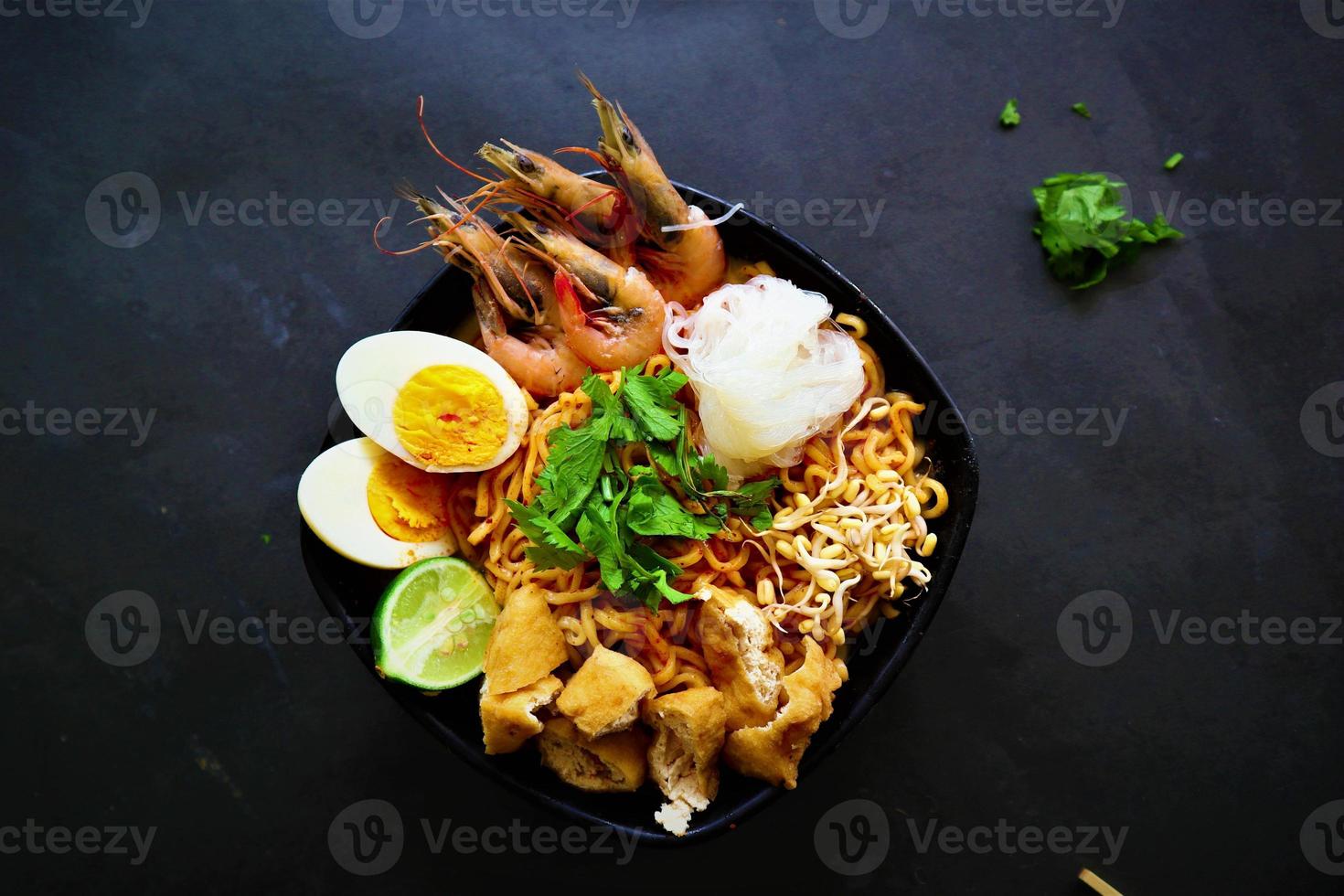 laksa, laksa curry made from vermicelli, noodles, bean sprouts, egg, tofu lime, and shrimp with a spicy soup sauce that is rich in spices. laksa served on bowl, isolated on white background. photo