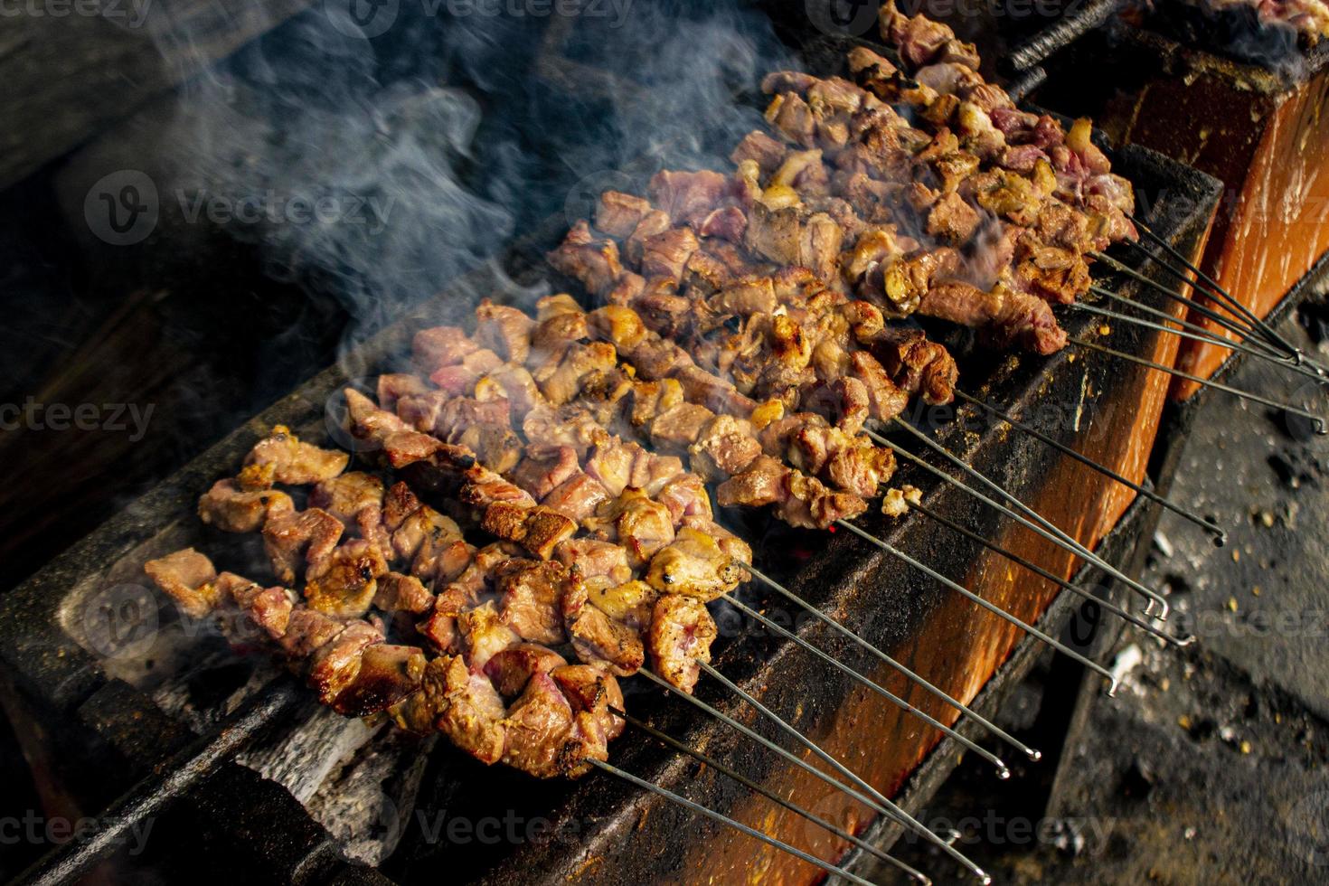 sate klatak o sate kambing o satay de cabra, cordero, cordero o carne de cabra satay con ingrediente de carbón en fuego rojo asado por personas, indonesia cocinando satay. con enfoque selectivo foto