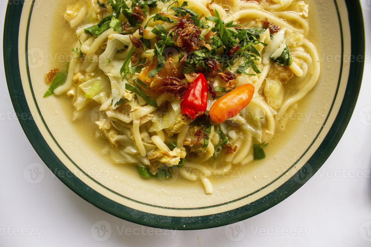 Mie godog Jawa or bakmi jawa or java noodle or Mie rebus or boiled noodles with spoon and fork. Indonesian traditional street food noodles from java, indonesia on white backgroud photo