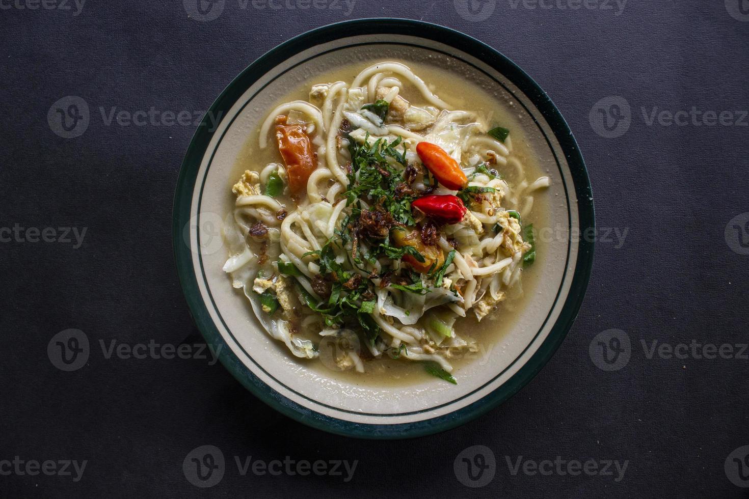 Mie godog Jawa or bakmi jawa or java noodle or Mie rebus or boiled noodles with spoon and fork. Indonesian traditional street food noodles from java, indonesia on white backgroud photo