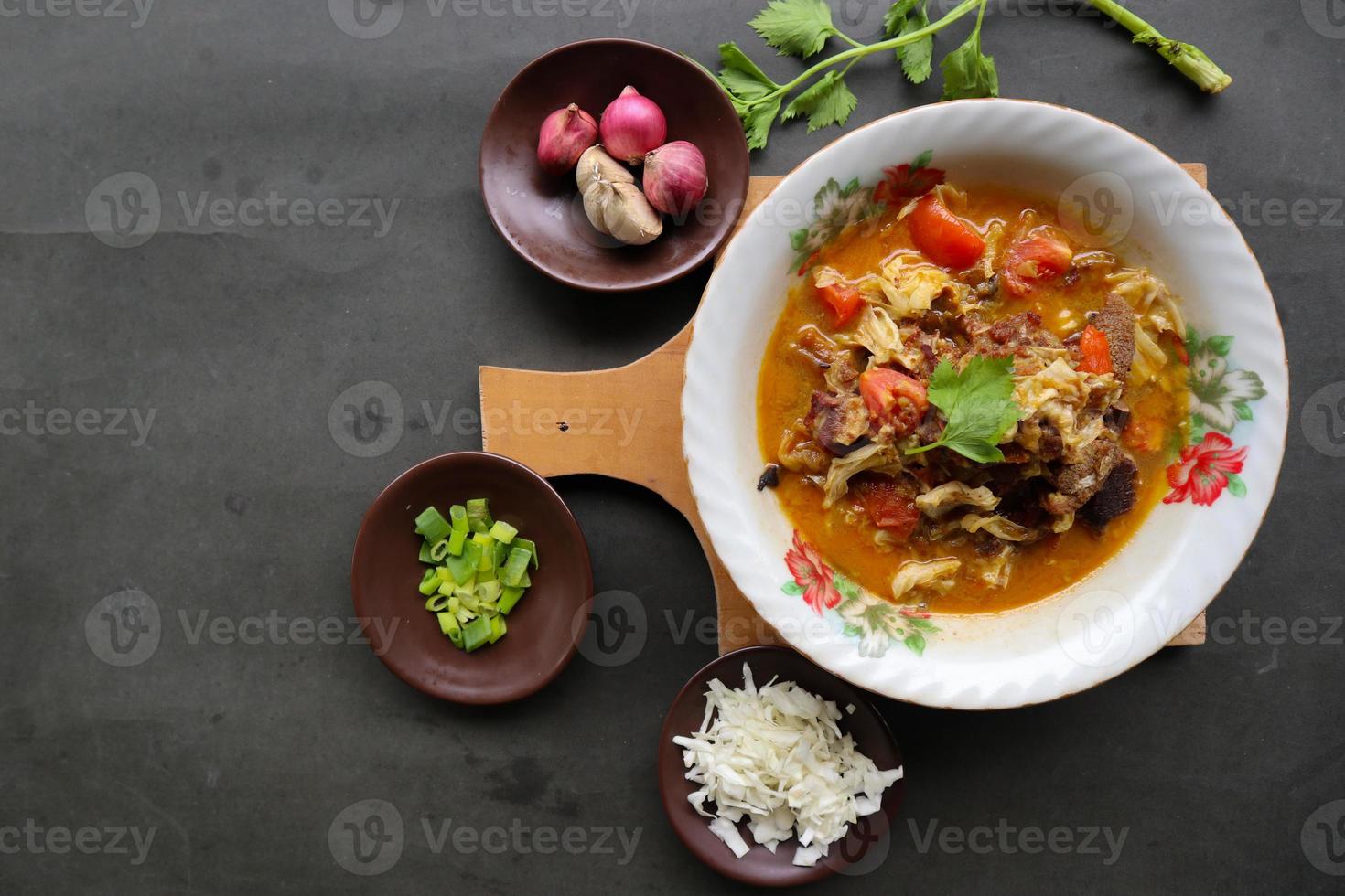 Goat Curry or gulai kambing, food from asia. Delicious goat meat curry served in a bowl.served with tomato, seasoning, celery and cabbage photo