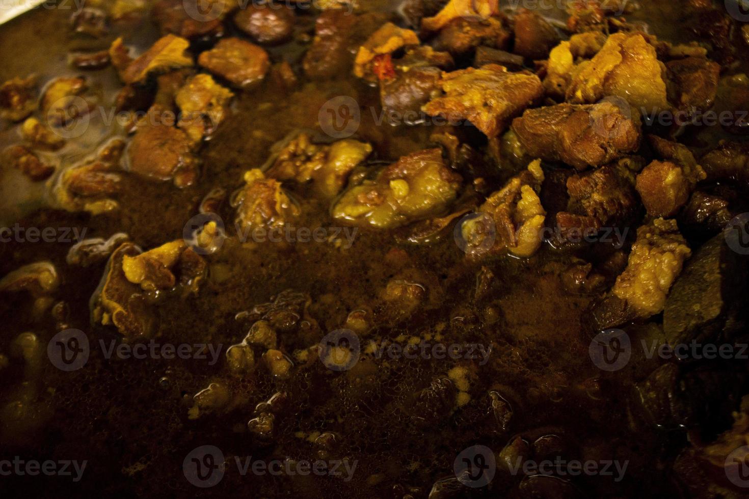 Traditional cooking raw meat with yellow curry or Tongseng in pan. Tongseng is traditional curry food from central java indonesia photo