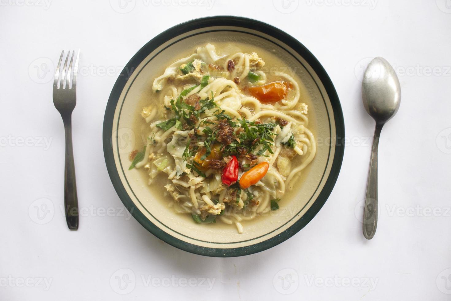 Mie godog Jawa or bakmi jawa or java noodle or Mie rebus or boiled noodles with spoon and fork. Indonesian traditional street food noodles from java, indonesia on white backgroud photo