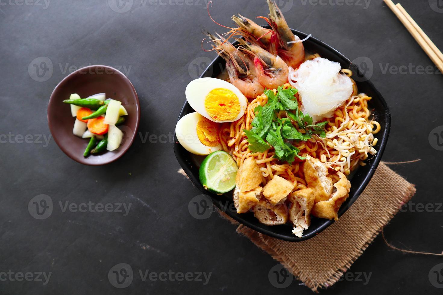 laksa, laksa curry made from vermicelli, noodles, bean sprouts, egg, tofu lime, and shrimp with a spicy soup sauce that is rich in spices. laksa served on bowl, isolated on white background. photo