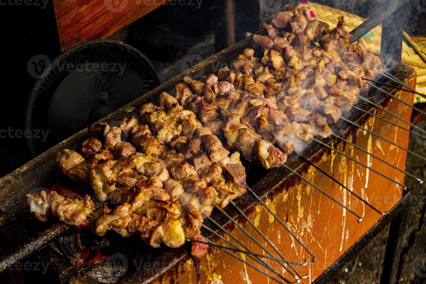 sate klatak or sate kambing or satay goat, lamb, Lamb or meat goat satay with charcoal ingredient on red fire grilling by people, Indonesia cooking satay. with selective focus photo