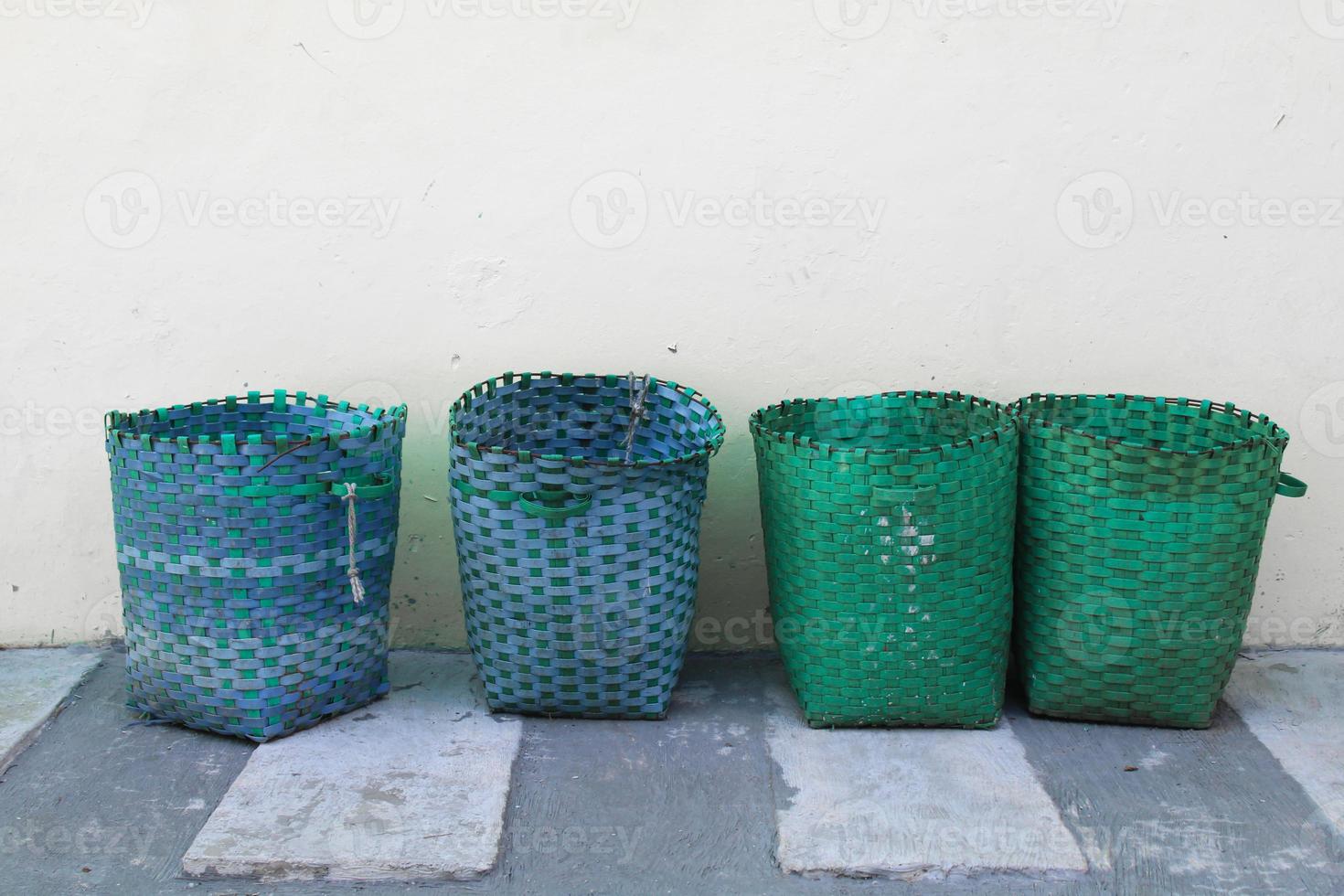 cesta, la cesta de plástico sirve como bote de basura. bote de basura afuera contra la pared foto