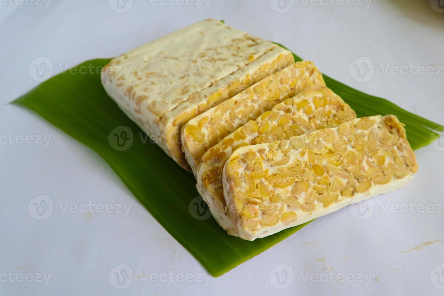 Raw tempeh or tempe. tempeh slices in white background. raw soybean seeds. Tempe is a traditional Indonesian food made from fermented soybeans. photo