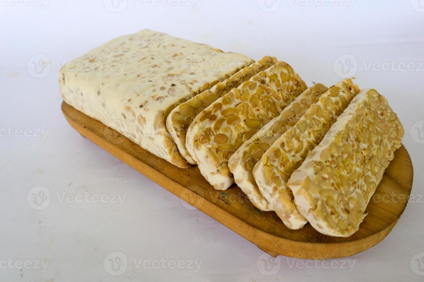 Raw tempeh or tempe. tempeh slices in white background. raw soybean seeds. Tempe is a traditional Indonesian food made from fermented soybeans. photo