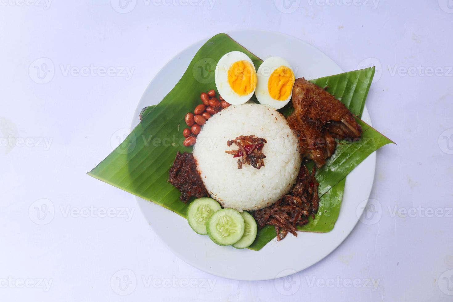 nasi lemak, is traditional malay made boiled eggs, beans, anchovies, chili sauce, cucumber. isolated on white background photo