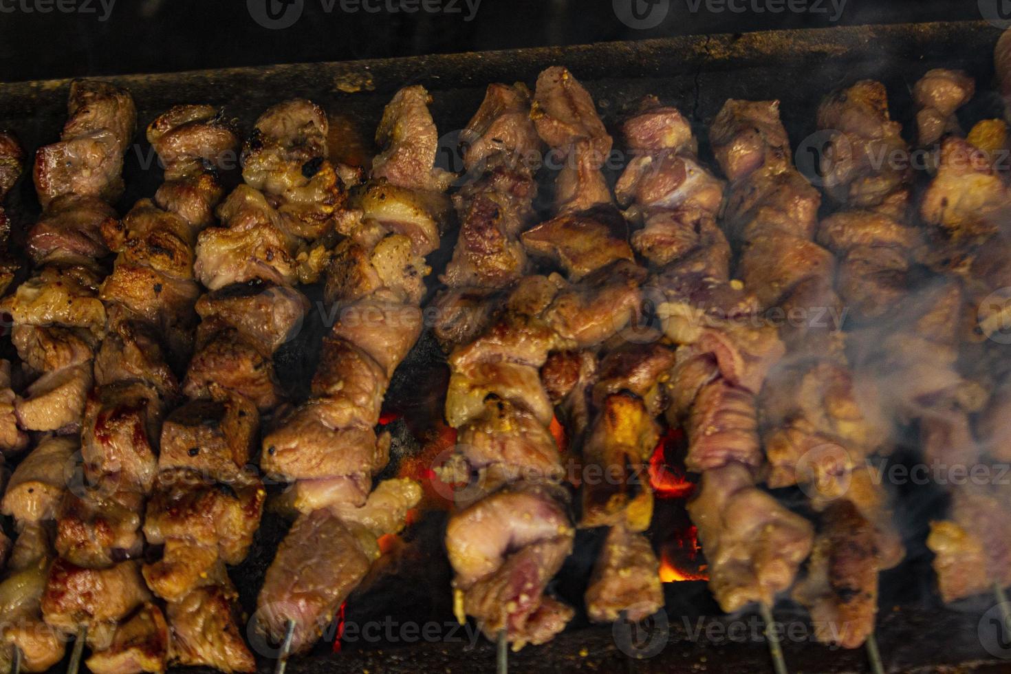 sate klatak o sate kambing o satay de cabra, cordero, cordero o carne de cabra satay con ingrediente de carbón en fuego rojo asado por personas, indonesia cocinando satay. con enfoque selectivo foto