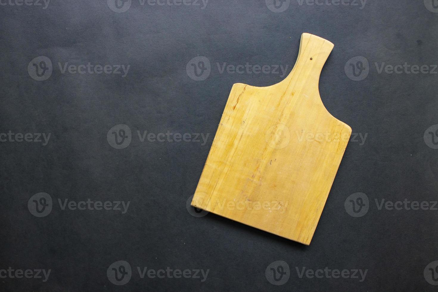 tabla de cortar de madera para cocinar. tabla de cortar de madera sobre fondo negro. vista superior con espacio de copia para texto. menú, receta, maqueta plana, fondo de banner foto